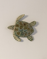 Decorative turtle wall art on a light-colored wall with a framed picture.
