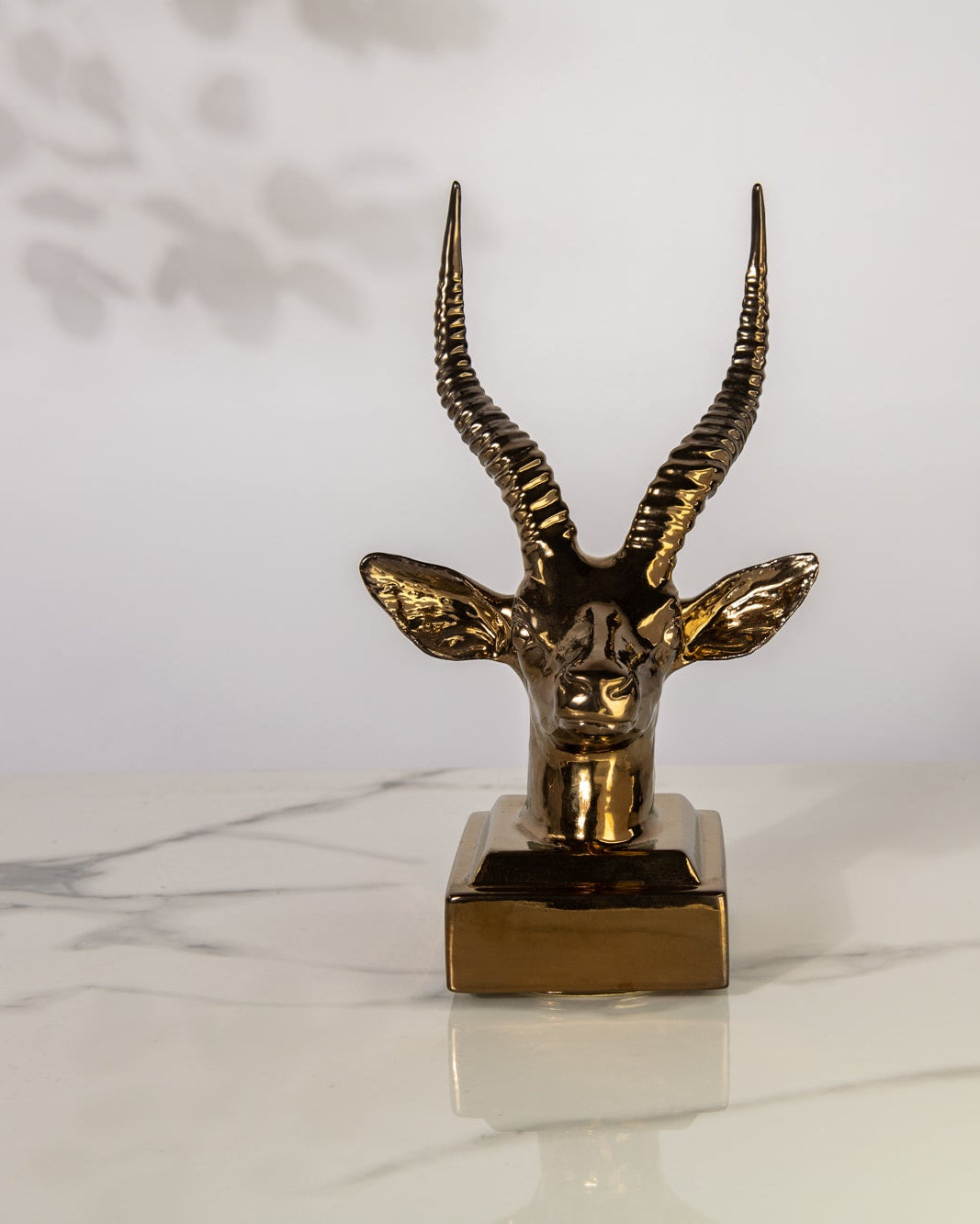Gold Springbok Statue on a marble table top and white back ground