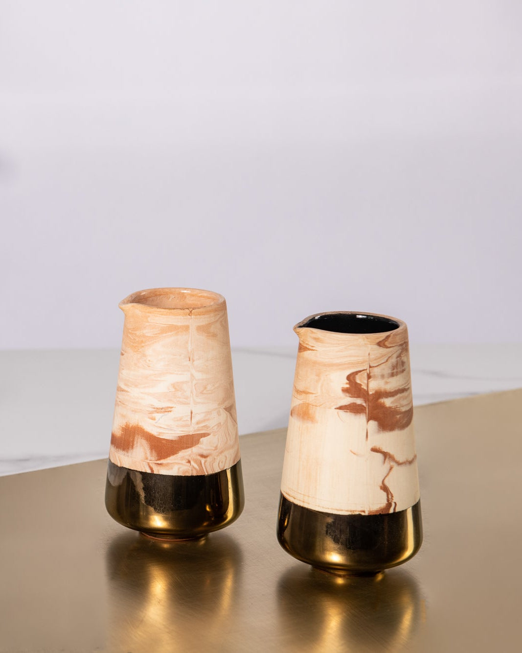 Rialheim Jug in an earthy finish with bronze rim on a gold sheet in a room