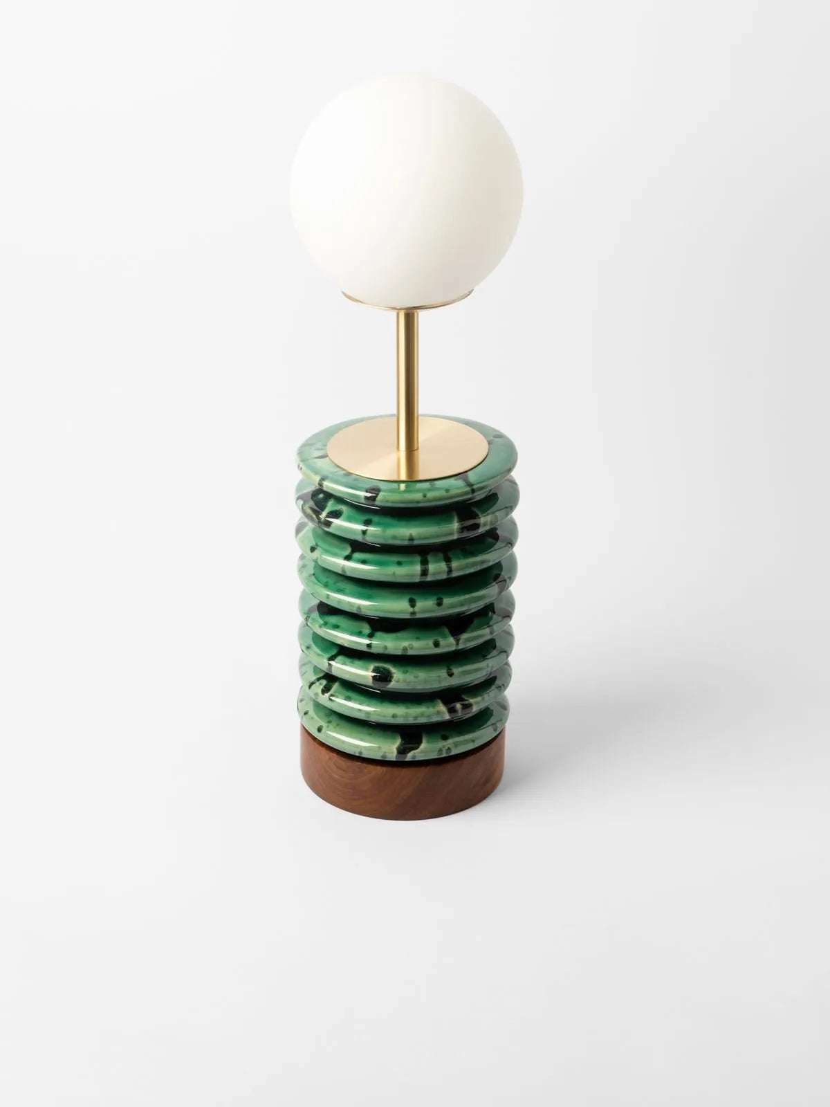 Rialheim Spring Table Lamp green and ribbed with black spots and a frosted bulb on a white back ground