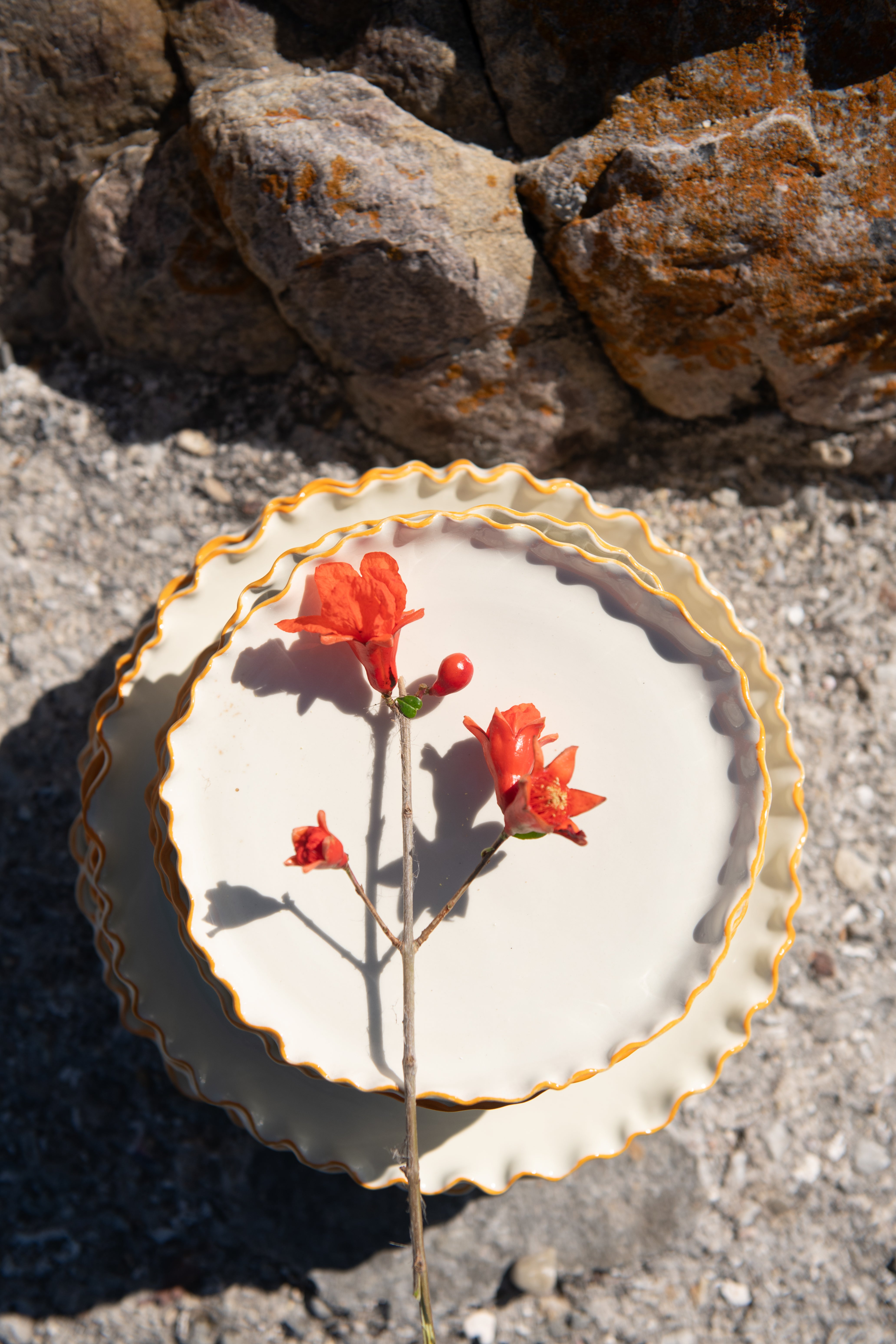 Decorative plate with red flowers on a stone surface