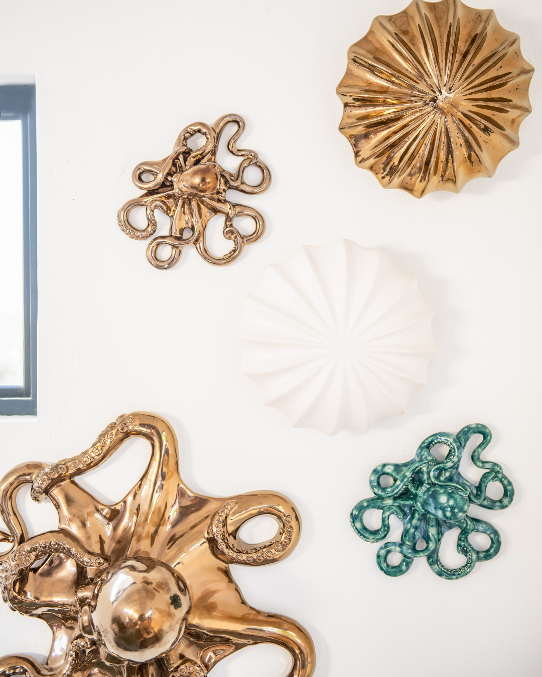 Decorative wall art pieces including Bronze octopus and shell designs on a white background.