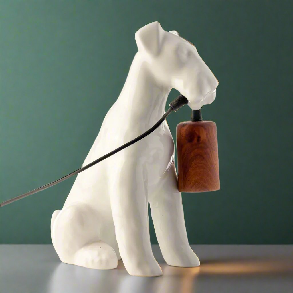 A table lamp shaped like an Airedale dog holding the bulb
