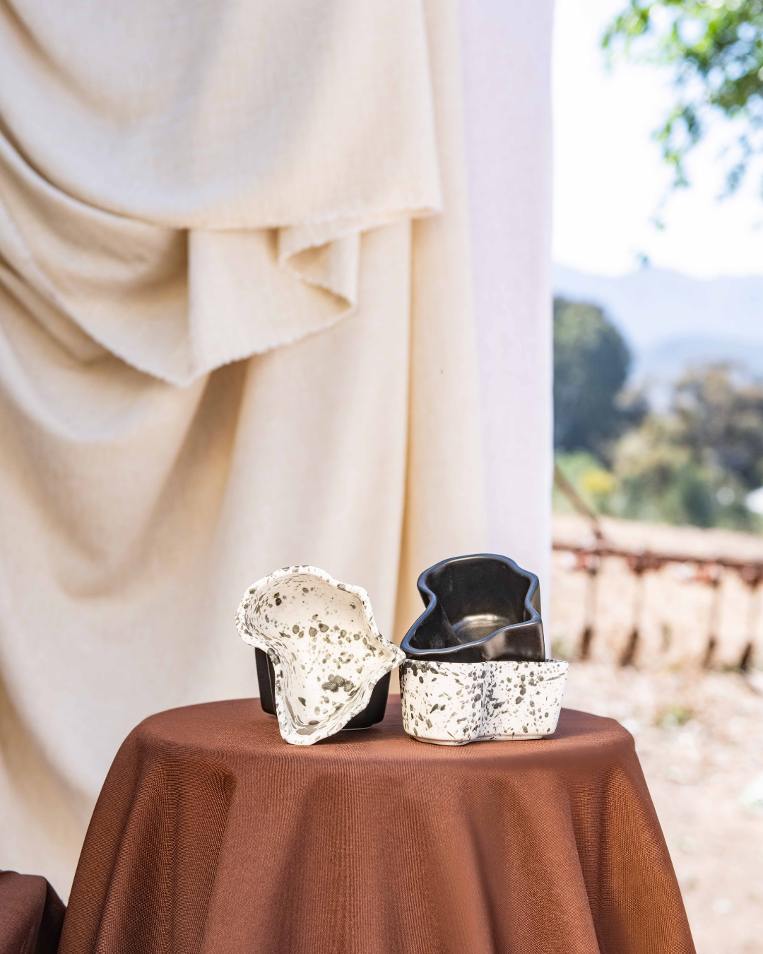 Dessert display in africa shaped ceramic bowls on a table with a scenic background