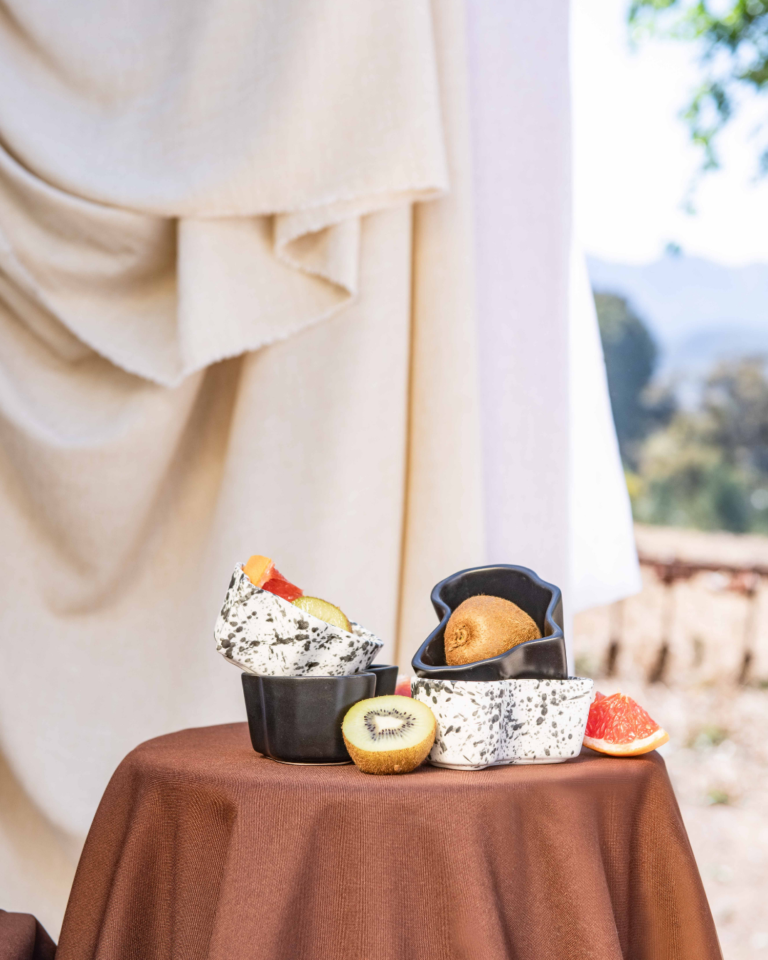 Dessert display in africa shaped ceramic bowls on a table with a scenic background