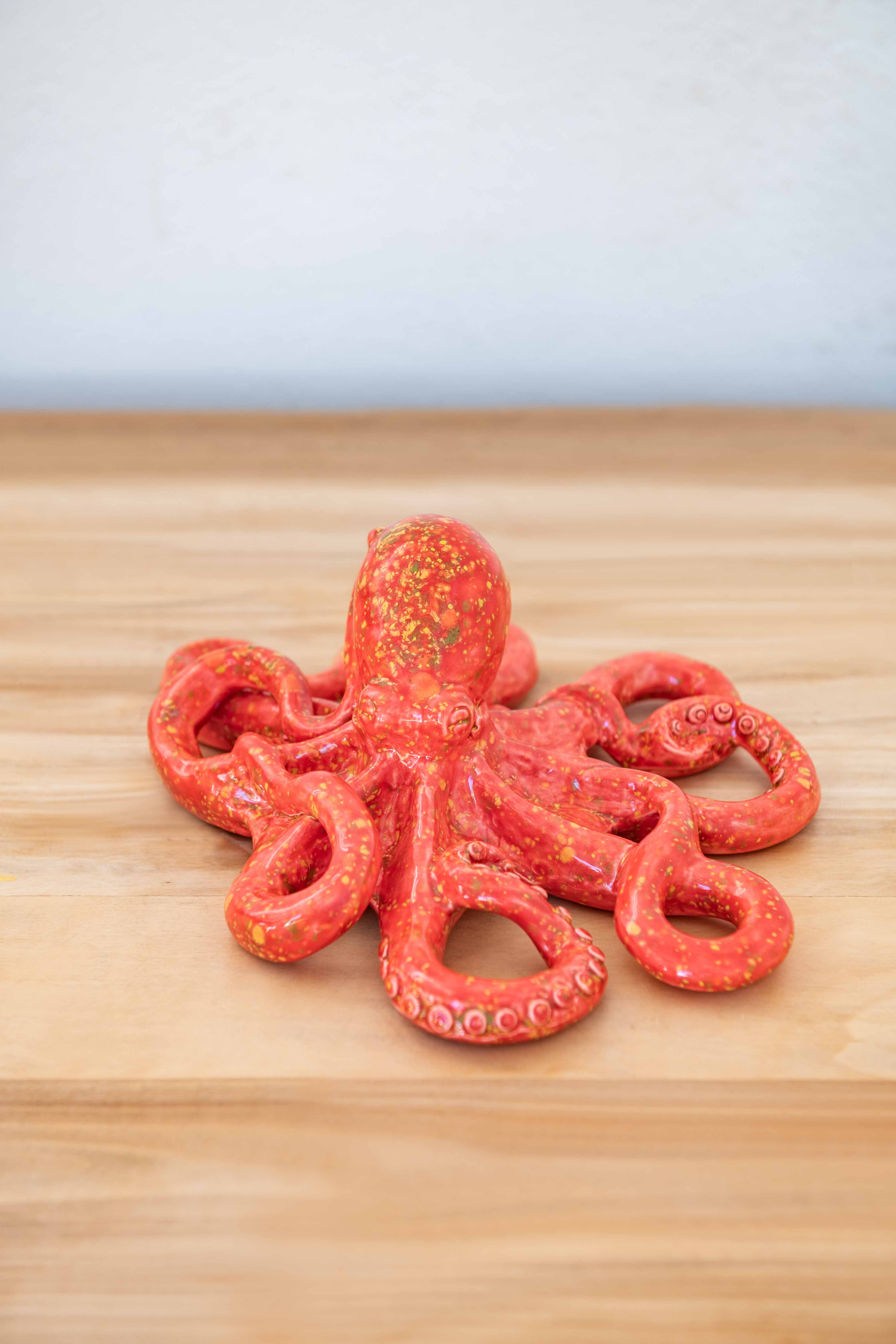 Rialheim ceramic Octopus on a table on white back ground in red lave crystal Glaze