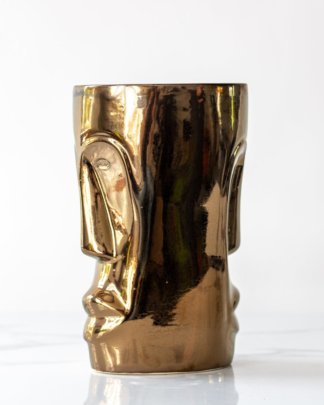 Vase in the shape of an African mask in ceramic glazed on Bronze on a marble surface