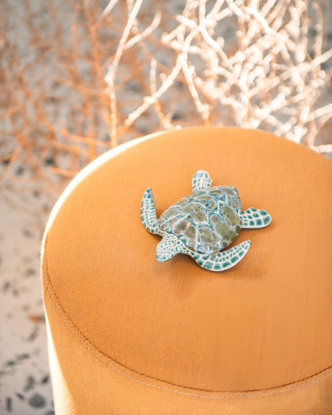 Decorative turtle ornament on a textured surface with a blurred natural background