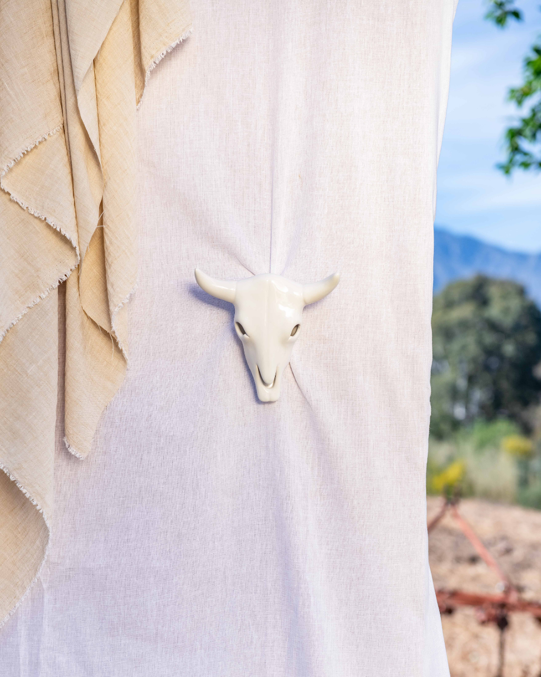 White bull head sculpture on a white background with blurred natural scenery