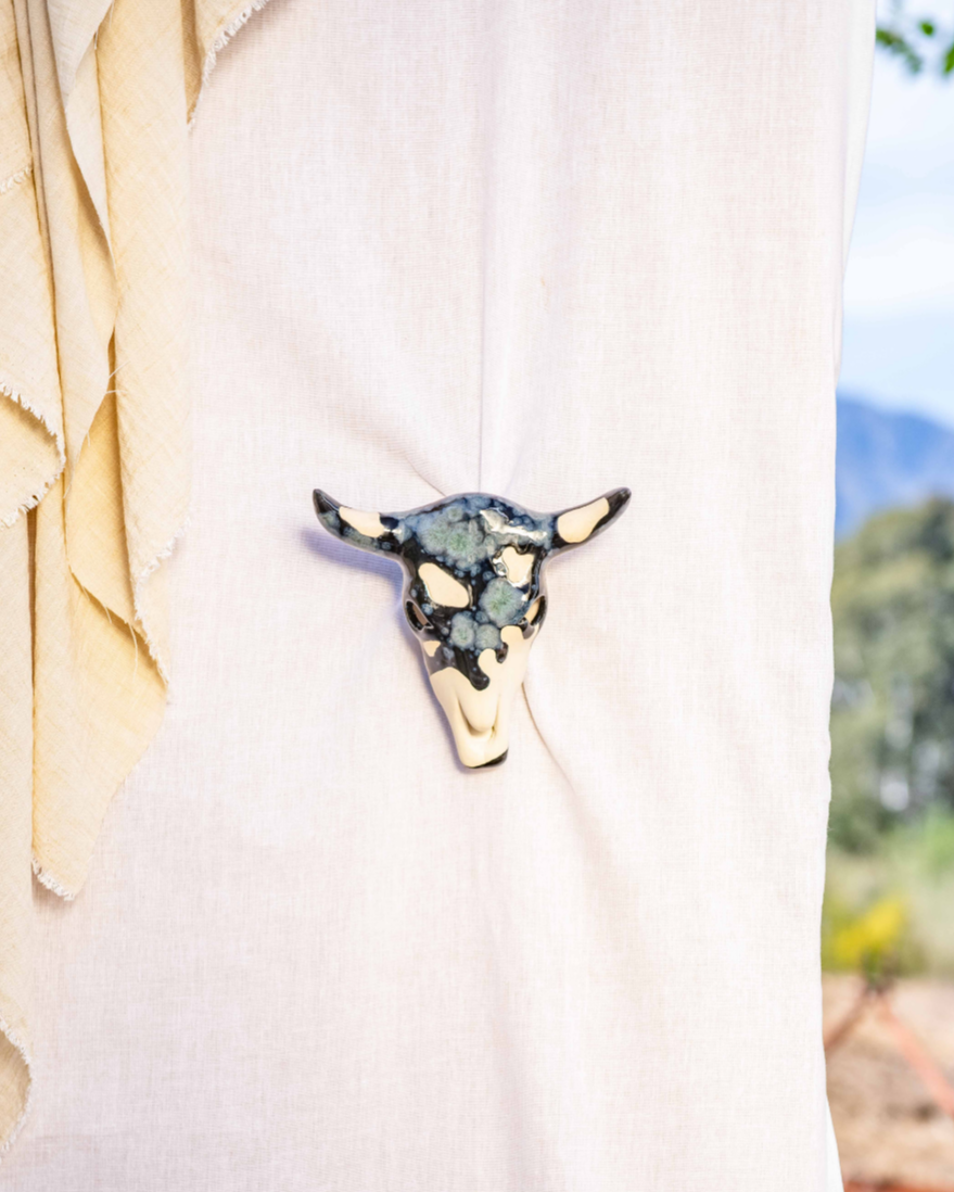 Bull head pin on a white shirt with a blurred natural background