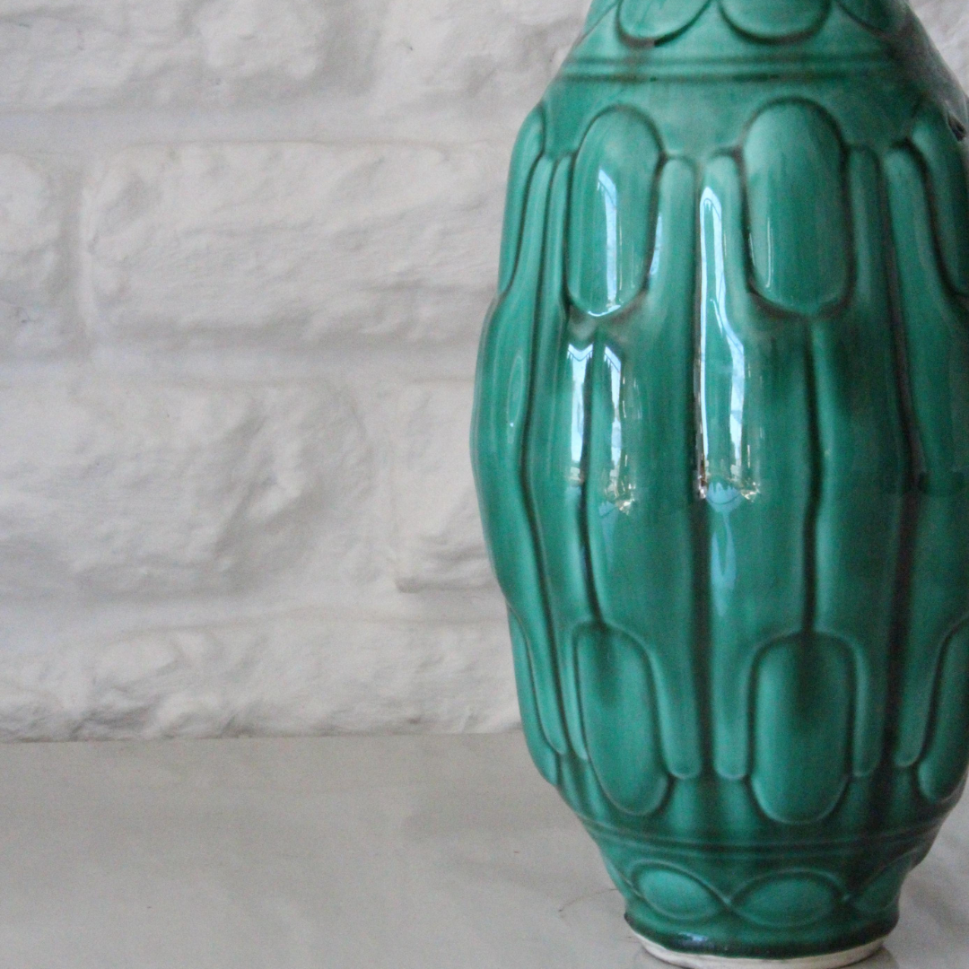 Green ceramic vase with textured design on a light gray background by RIalheim 
