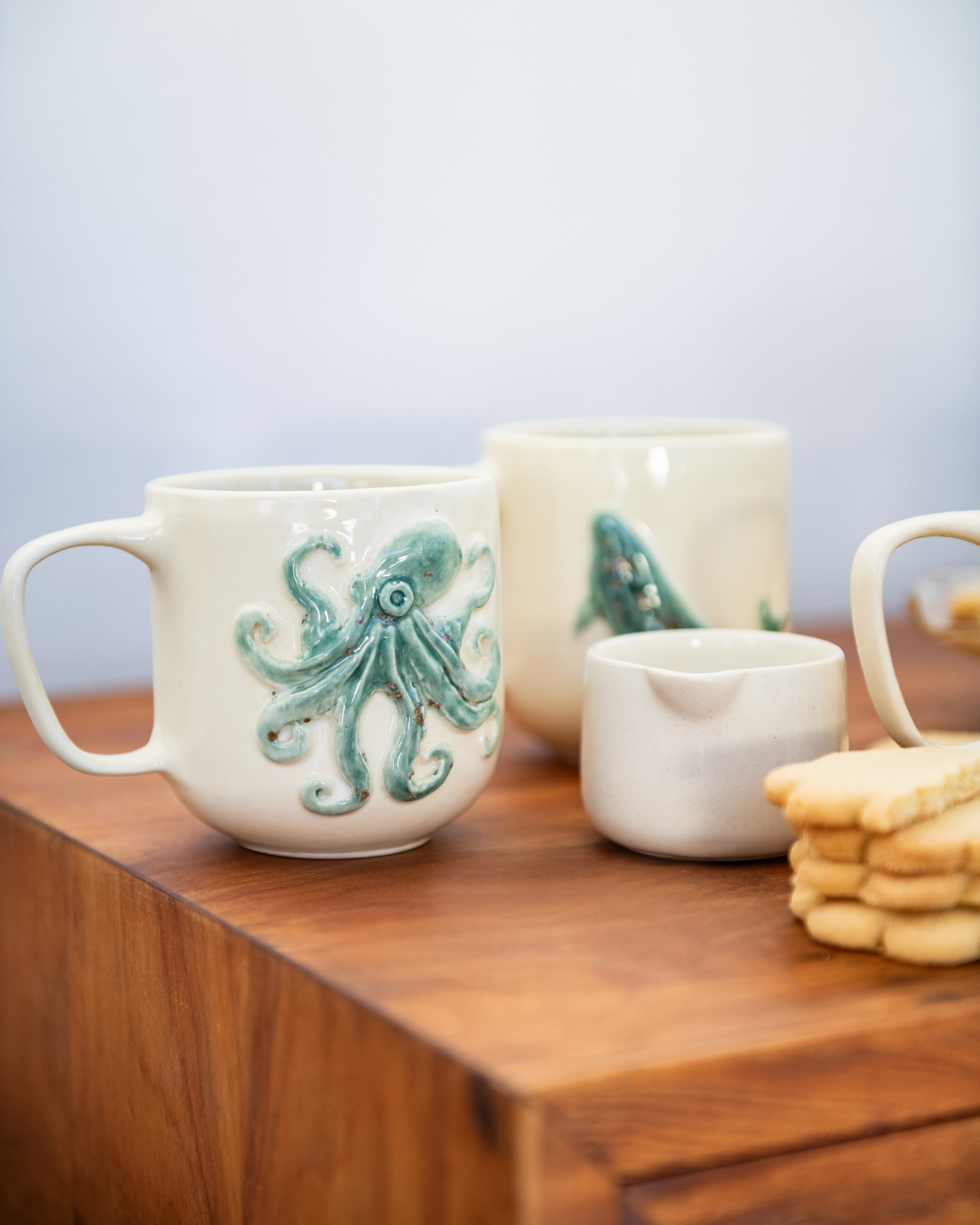 Ceramic mugs with octopus design on a wooden surface