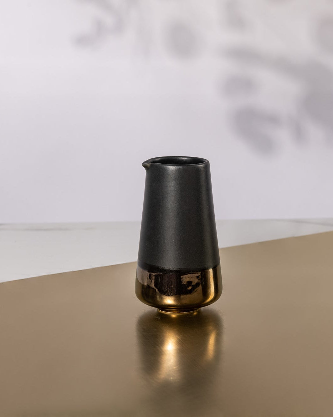 Black and bronze milk Jug on a golden sheet