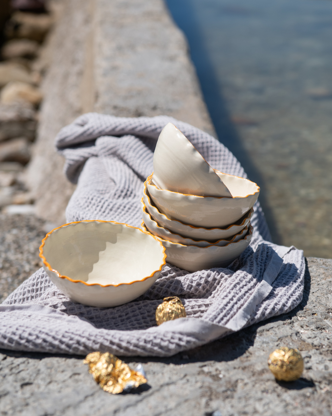 Stack of ceramic bowls on a textured surface with a blurred natural background