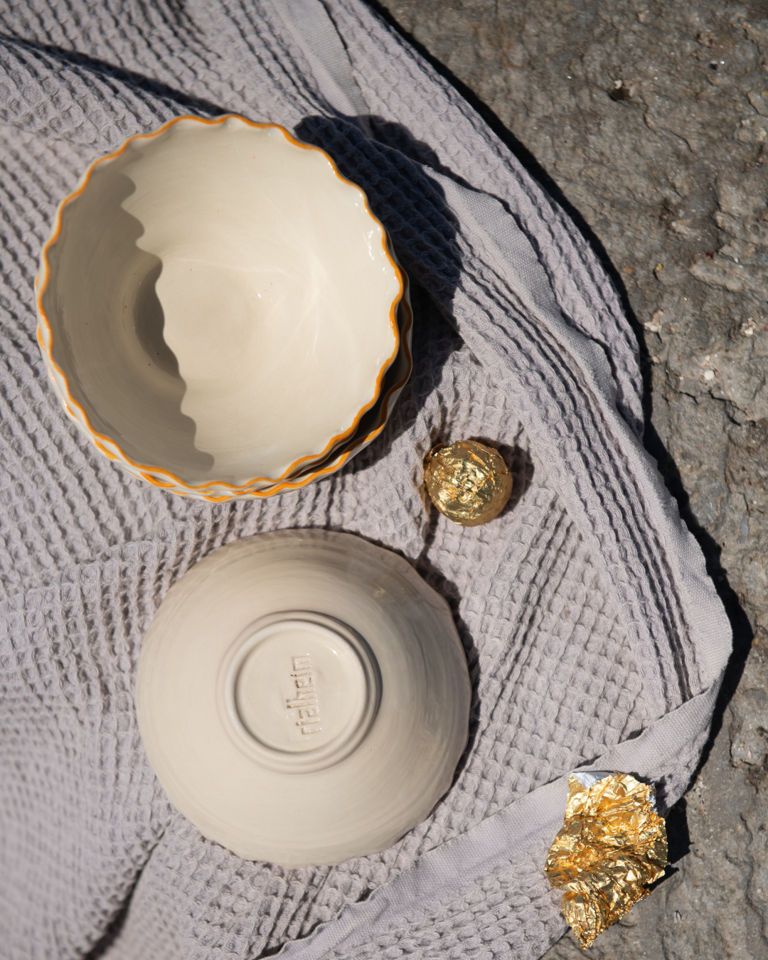 Two ceramic bowls with coral rims on a textured surface. Made out of Ceramics by RIalheim 