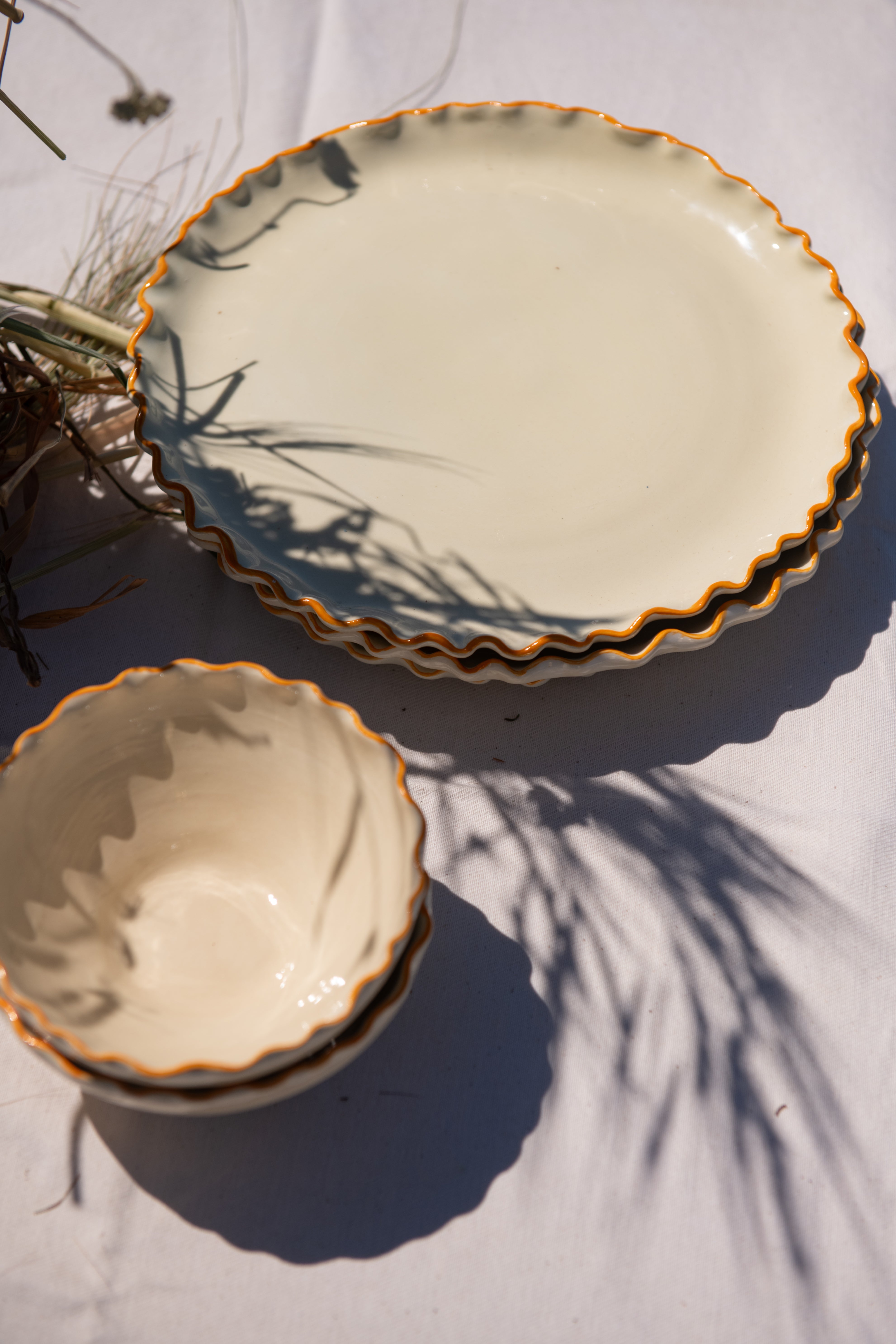 Two ceramic bowls with scalloped edges on a light surface