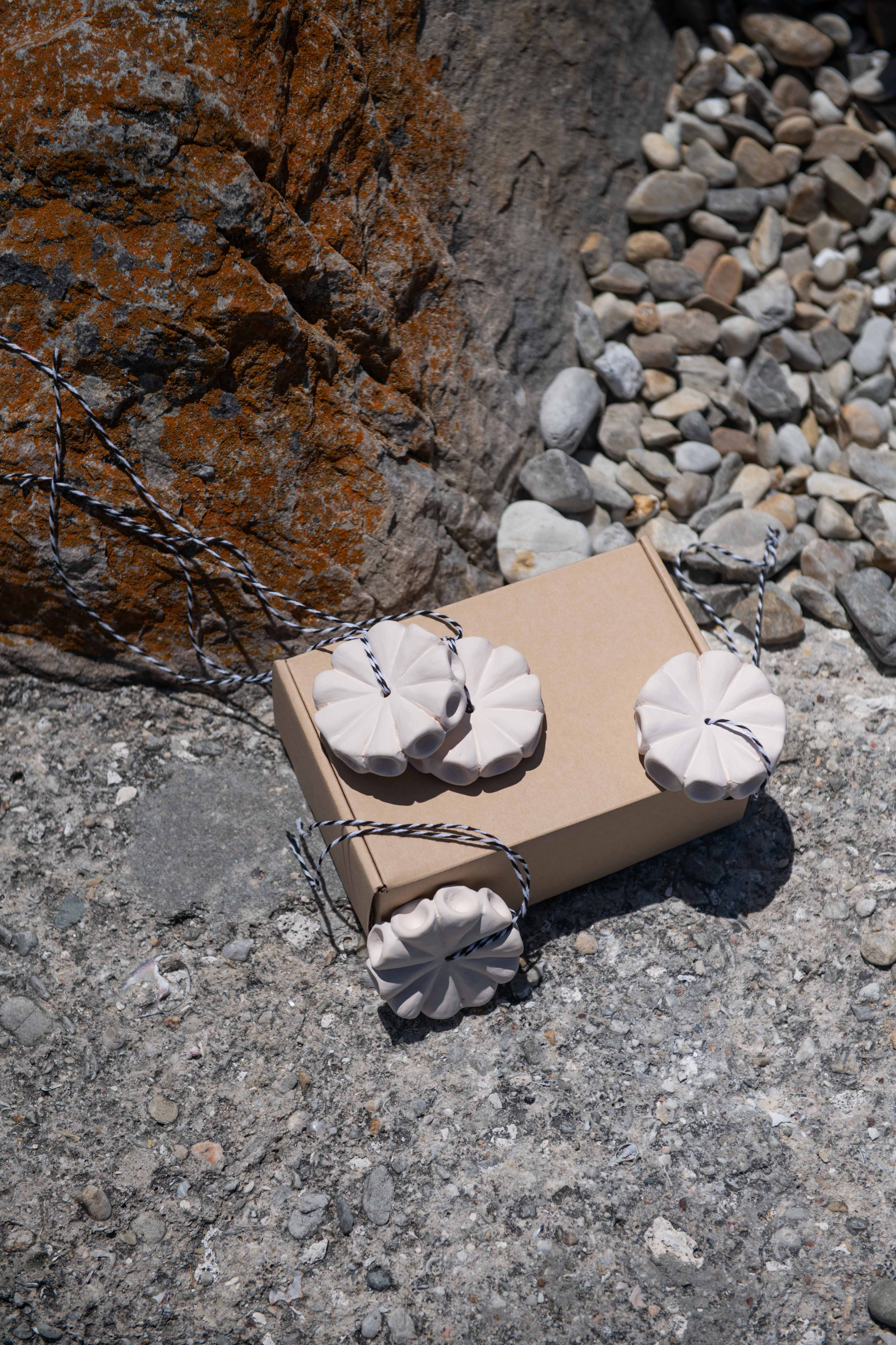 Cardboard box with white decorative items on a stone surface
