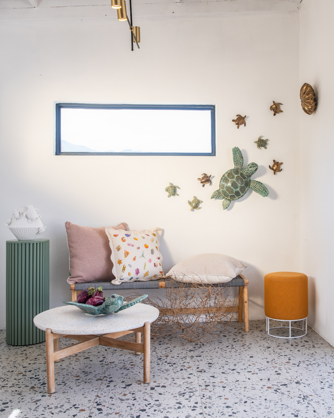 Modern living room with a sofa, coffee table, and decorative wall sea turtles in jade and Bronze 