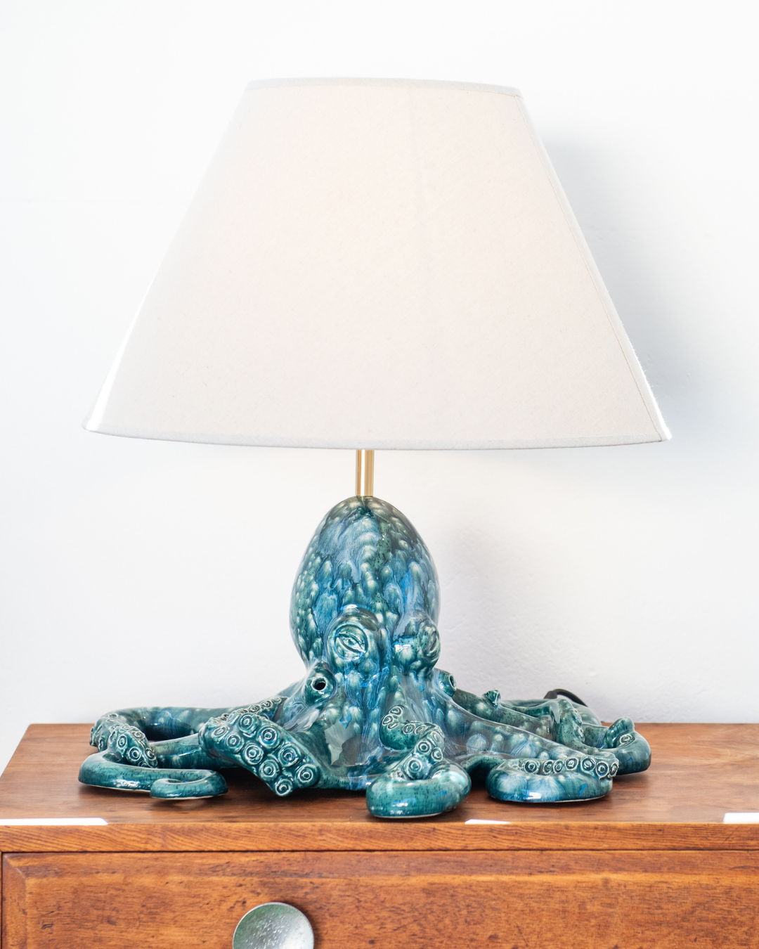 Decorative lamp with a blue octopus design on a wooden surface.
