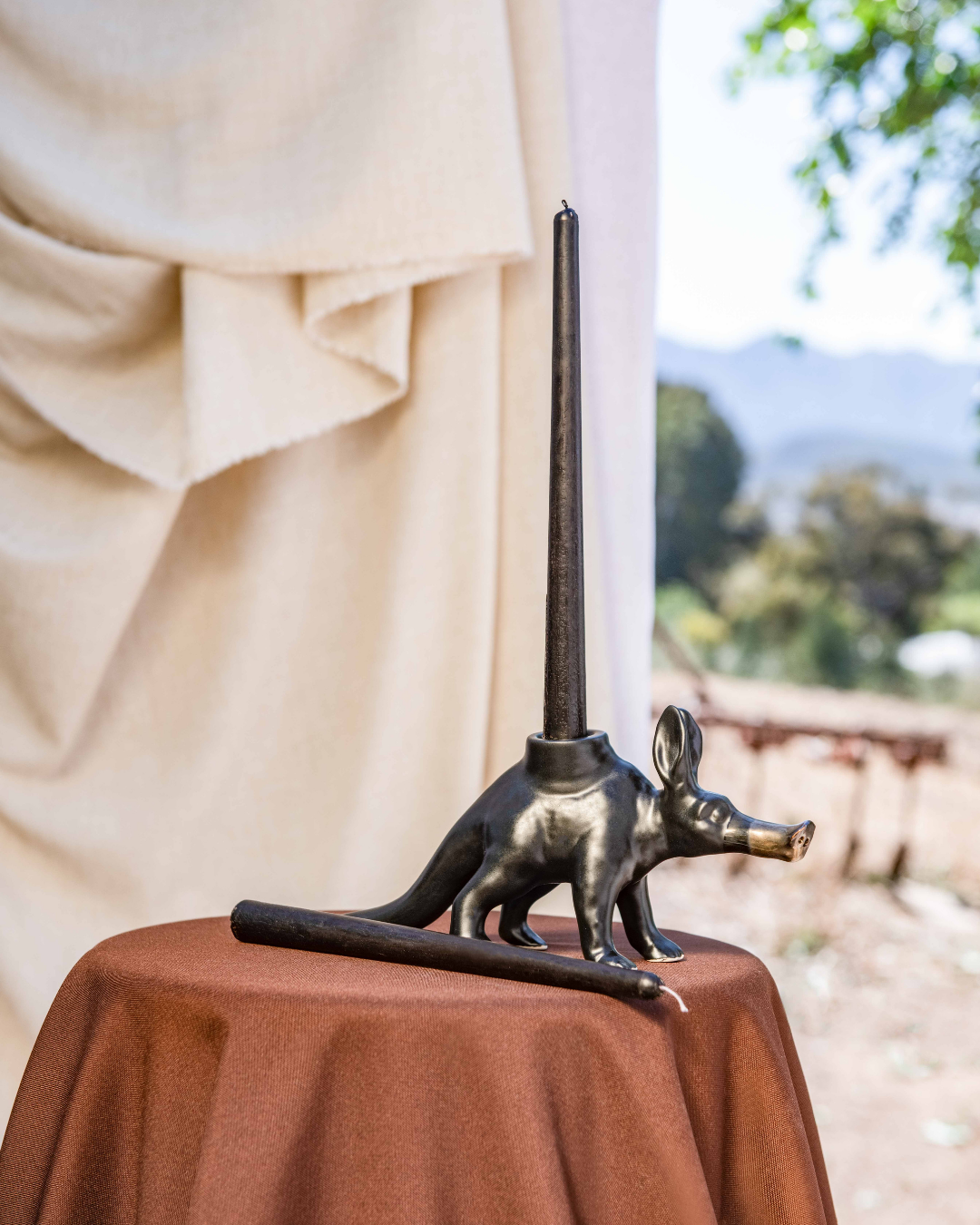 matt black Aardvark candle Holder on a brown cloth in nature