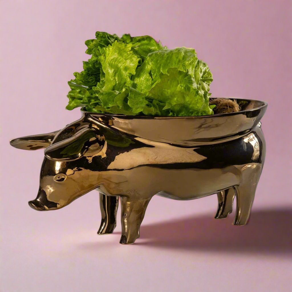 A white ceramic fruit bowl shaped like a pig, with intricate details and a curved body, perfect for displaying fresh fruit or using as a unique centerpiece in any kitchen or dining room.