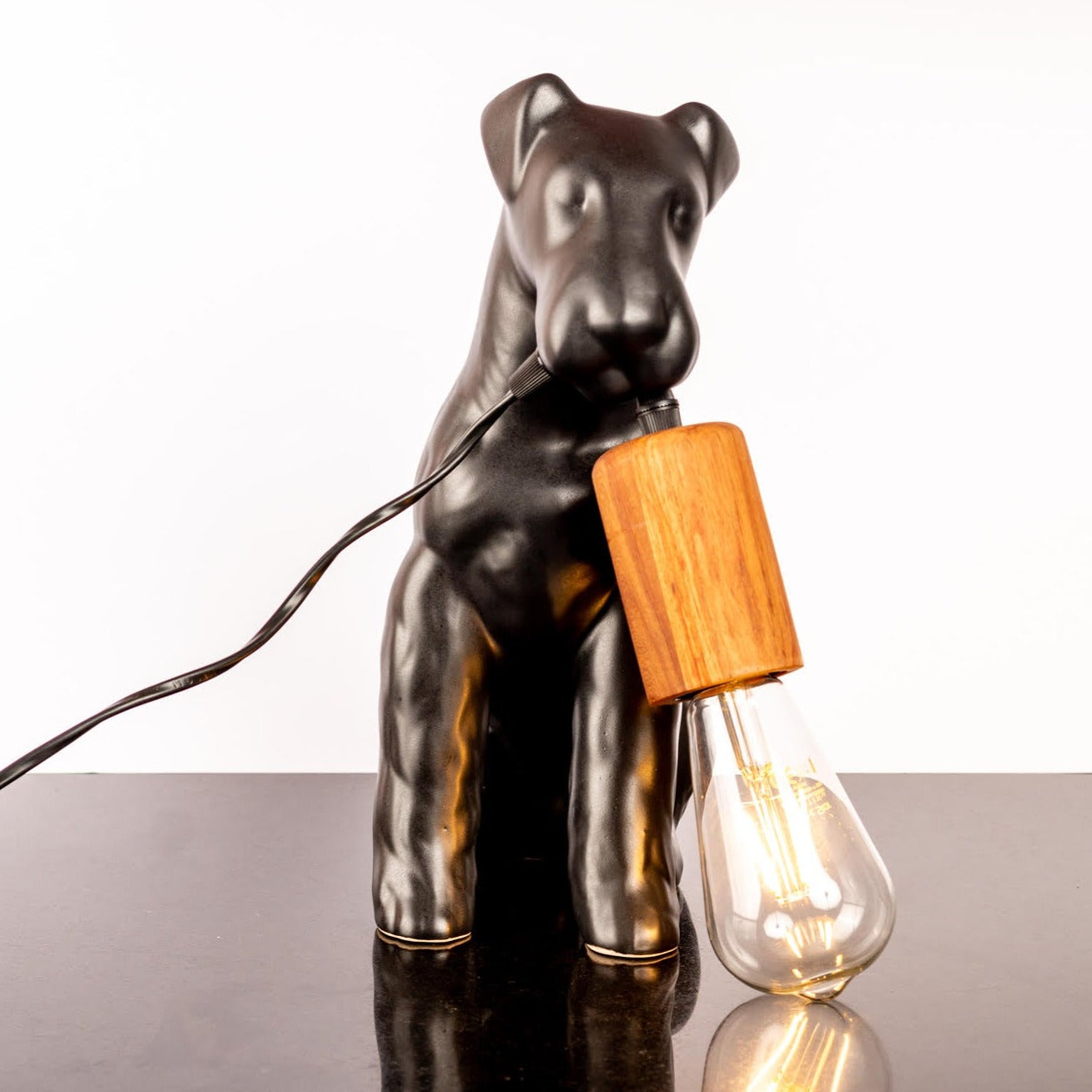 AIREDALE TABLE LAMP - Rialheim A table lamp shaped like an Airedale dog holding the bulb