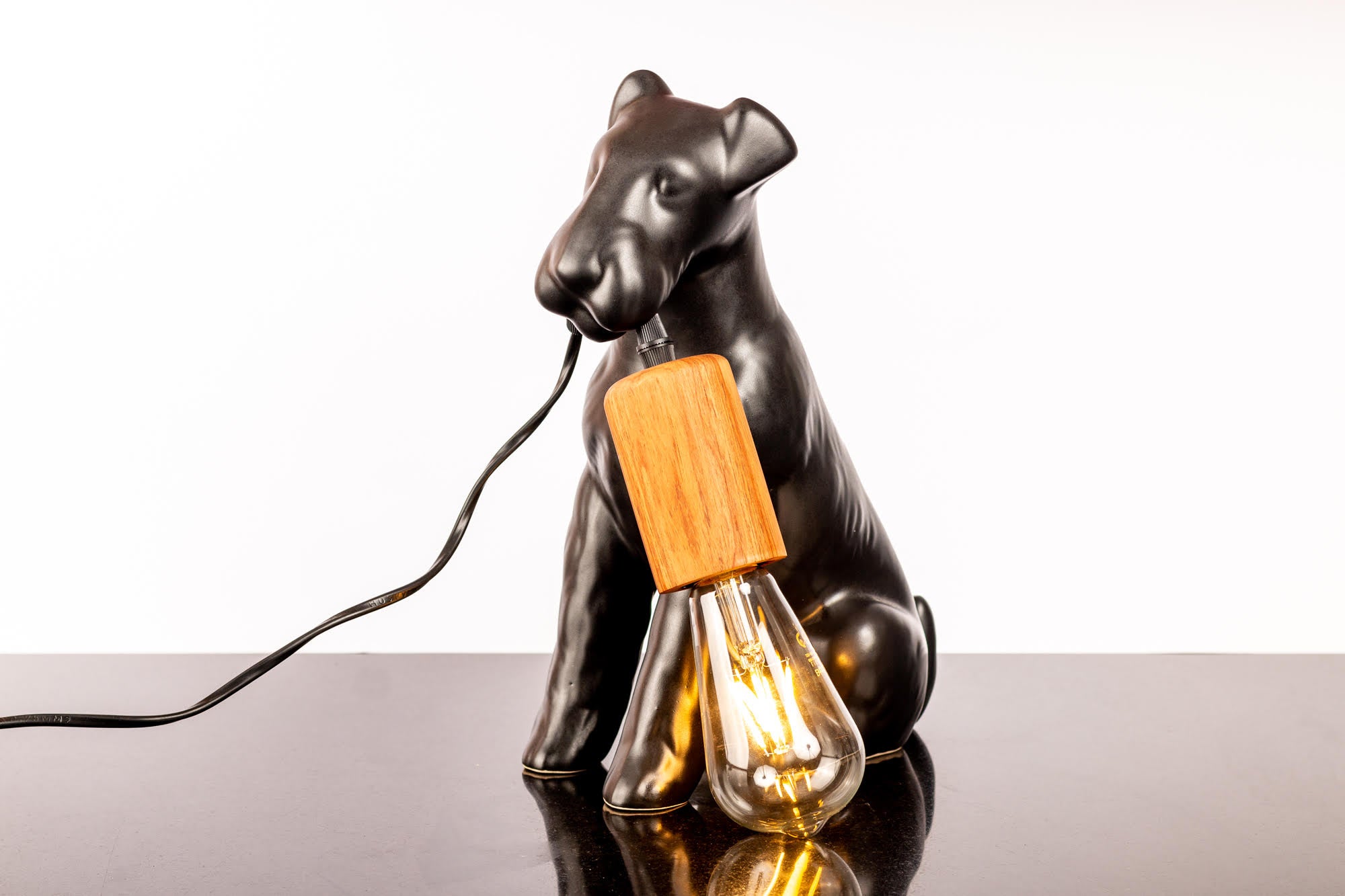 AIREDALE TABLE LAMP - Rialheim A table lamp shaped like an Airedale dog holding the bulb