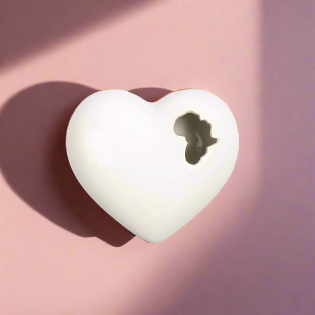 A handcrafted ceramic heart-shaped wall art piece, with intricate details and an African-inspired design, perfect for adding a touch of cultural pride and beauty to any home decor.